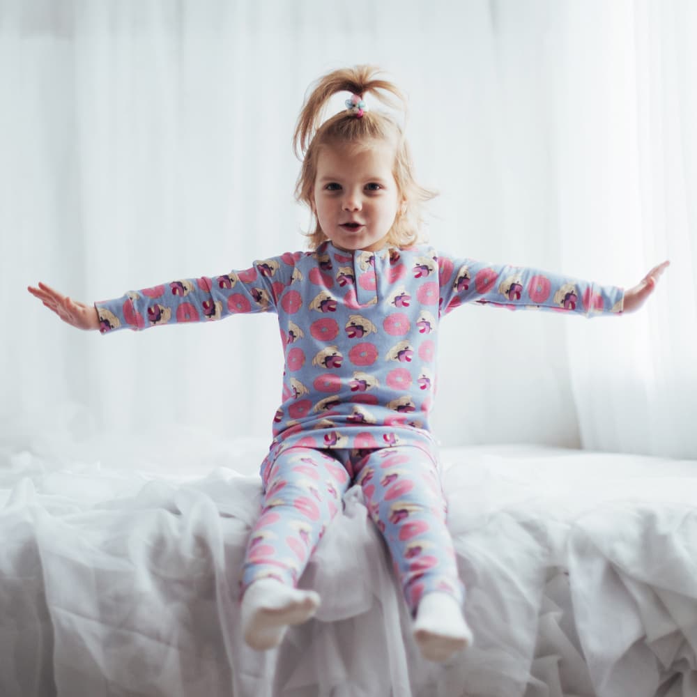 Little girl posing on bed in custom pajama sets