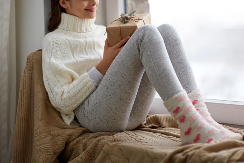 Girl sitting cozily on a warm bed in fleece lined leggings